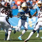 Melvin Gordon #25 of the Los Angeles Chargers runs the ball as Kareem Jackson #22 and Alexander Johnson #45 of the Denver Broncos defend during the first half of a game at Dignity Health Sports Park on October 06, 2019 in Carson, California. (Photo by Sean M. Haffey/Getty Images)