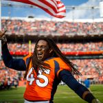 DENVER, CO - NOVEMBER 3: Linebacker Alexander Johnson #45 of the Denver Broncos hands an American Flag over to a member of the military on the field before  game against the Cleveland Browns at Empower Field at Mile High on November 3, 2019 in Denver, Colorado. (Photo by Justin Edmonds/Getty Images)