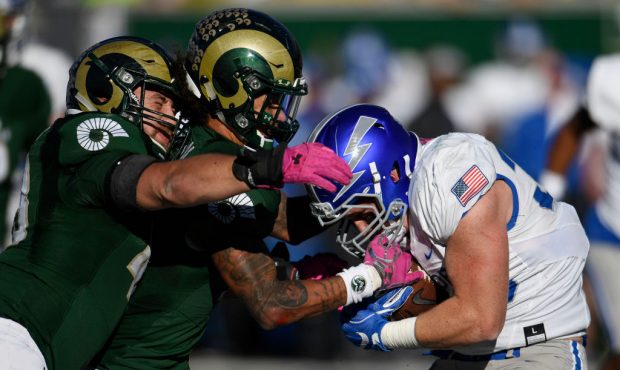 Colorado State Rams safety Jordan Fogal #11, center, tries to strip the ball away from Air Force Fa...