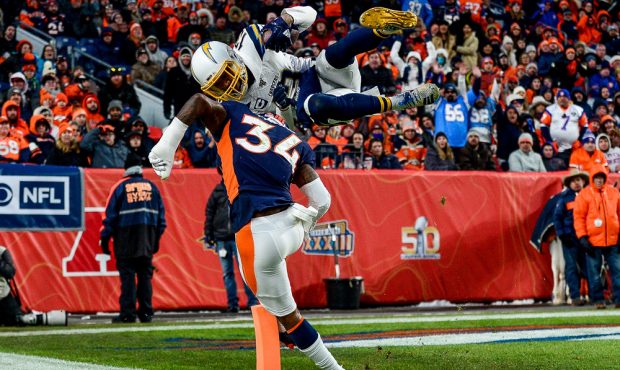 DENVER, CO - DECEMBER 1: Keenan Allen #13 of the Los Angeles Chargers leaps over Will Parks #34 of ...