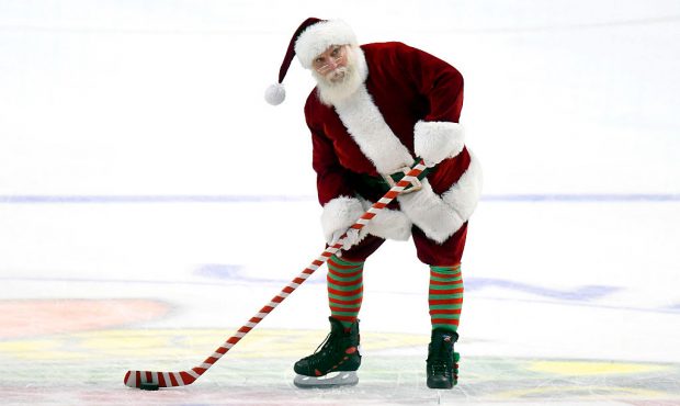 Santa Clause shoots the puck before the start of the third period of a game between the Colorado Av...