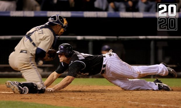 Matt Holliday #5 of the Colorado Rockies dives home with the winning run on a base hit by Jamey Car...