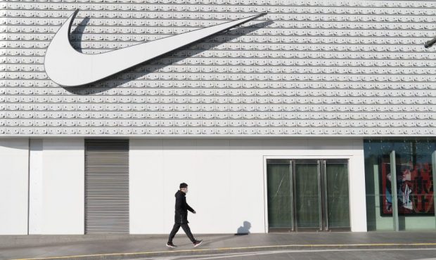 A man wearing a face mask walks past a Nike store in Central Business District, Beijing, China on F...