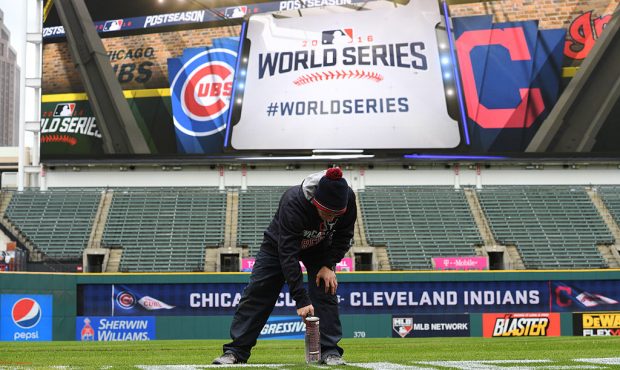 A member of the Cleveland Indians grounds crew paints the World Series logo on the field prior to M...