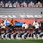 Denver Broncos players lock arms and kneel during the national anthem before a game against the Tennessee Titans at Empower Field at Mile High on September 14, 2020 in Denver, Colorado. (Photo by Dustin Bradford/Getty Images)