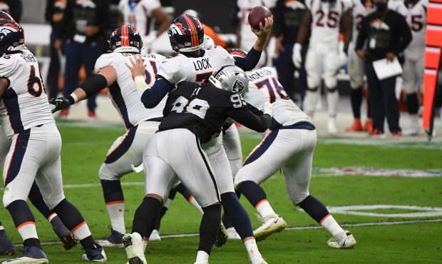 LAS VEGAS, NEVADA - NOVEMBER 15: Drew Lock #3 of the Denver Broncos is hit by Arden Key #99 of the ...