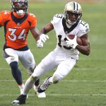 DENVER, COLORADO - NOVEMBER 29: Michael Thomas #13 of the New Orleans Saints carries after a reception ahead of defender Essang Bassey #34 of the Denver Broncos during the second quarter of a game at Empower Field At Mile High on November 29, 2020 in Denver, Colorado. (Photo by Matthew Stockman/Getty Images)