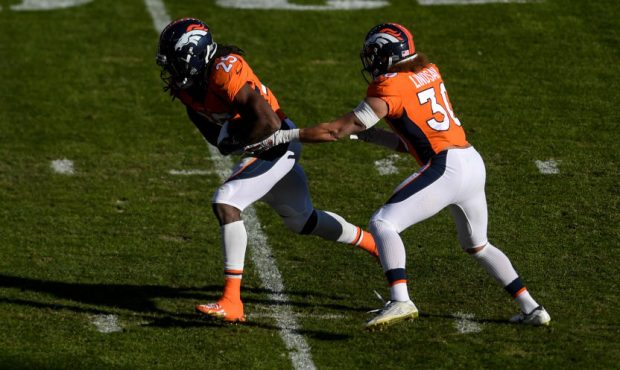 DENVER, CO - NOVEMBER 29: Phillip Lindsay (30) of the Denver Broncos hands off to Melvin Gordon III...