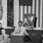 Home run King, Hank Aaron, of the Atlanta Braves, takes part in Flag Day Ceremonies on the floor of the House of Representatives. In the background is House Speaker Carl Albert.