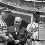 Milwaukee Braves third baseman Ed Mathews (L) and right fielder Hank Aaron received awards before the Braves-Chicago Cubs game here. They are shown with National League President Warren Giles. Aaron is shown with his silver bat and plaque for being the leading batter in 1959 and Mathews for leading the league in home runs.