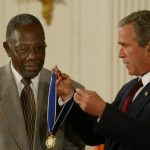 U.S. President George W. Bush presents baseball great Hank Aaron with the Presidential Medal of Freedom Award during a ceremony July 9, 2002 at the White House in Washington, DC. The medal is the highest civilian award given to those who have made meritorious contributions to the security or national interests of the United States, to world peace, or to cultural or other significant public or private endeavors.  (Photo by Mark Wilson/Getty Images)