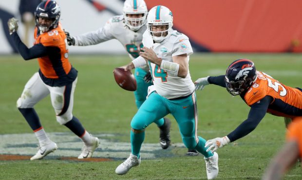 DENVER, COLORADO - NOVEMBER 22: Ryan Fitzpatrick #14 of the Miami Dolphins falls as he is tackled b...