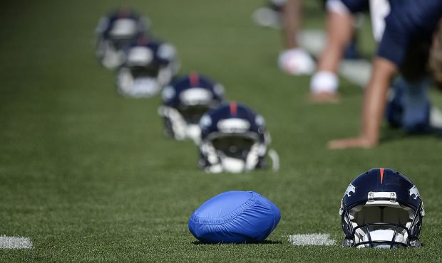 ENGLEWOOD, CO - JULY 24: Denver Broncos quarterback Peyton Manning (18) sets his football in a blue...