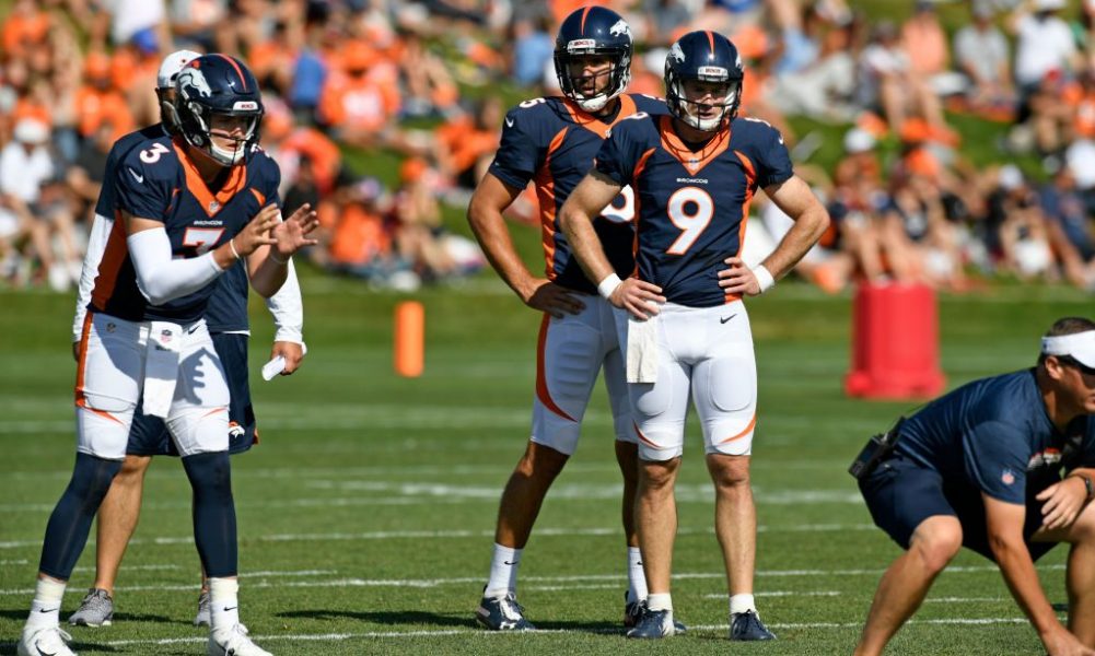 Denver Broncos quarterback Joe Flacco, right, talks with former