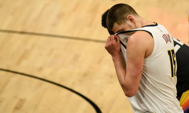 PHOENIX, AZ - JUNE 7: Nikola Jokic (15) of the Denver Nuggets wipes sweat from his face as Devin Bo...