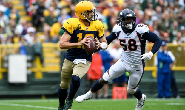 GREEN BAY, WI - SEPTEMBER 22: Aaron Rodgers (12) of the Green Bay Packers eludes Von Miller (58) of...
