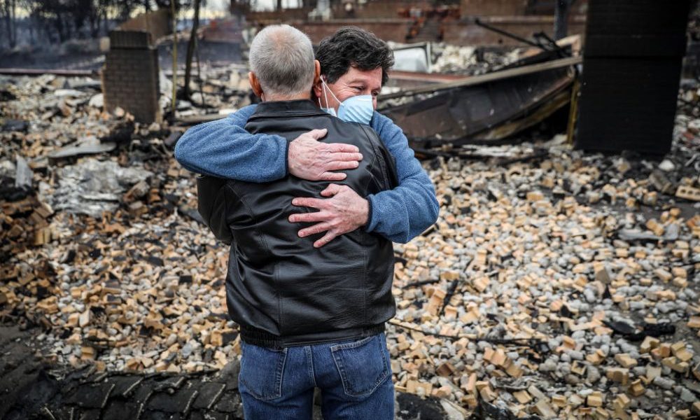 LOUISVILLE, CO - DECEMBER 31: Neighbors Louie Delaware (L) and Roy Nelson hug in the rubble of Dela...