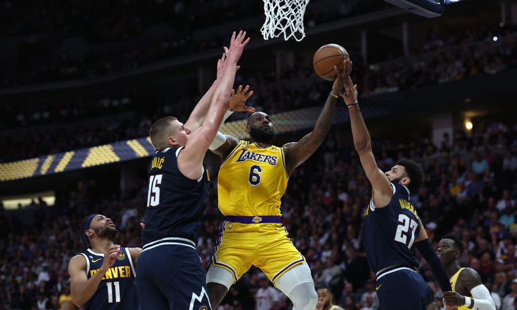 LeBron James #6 of the Los Angeles Lakers drives to the basket against Nikola Jokic #15 and Jamal M...