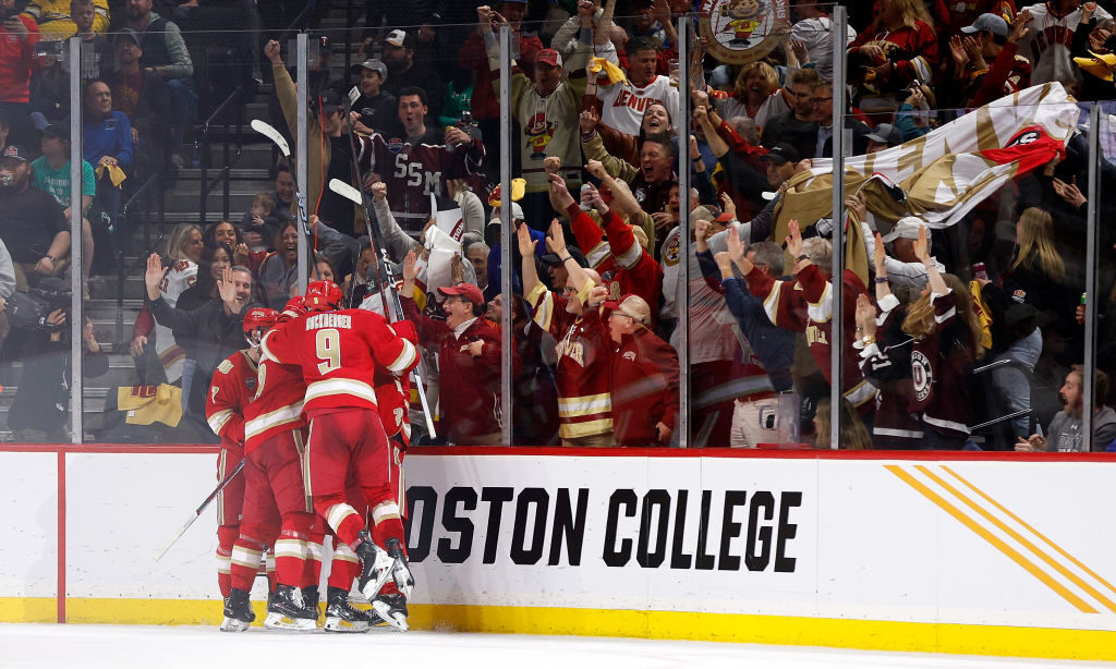Members of the Denver Pioneers celebrate a goal against the Boston University Terriers in the secon...