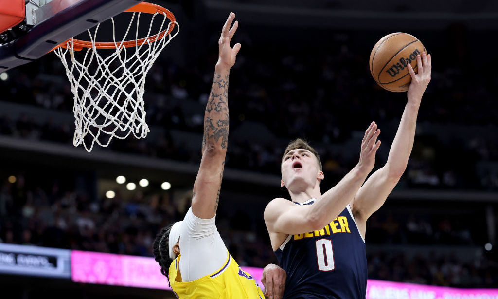 Christian Braun #0 of the Denver Nuggets puts up a shot against Anthony Davis #3 of the Los Angeles...