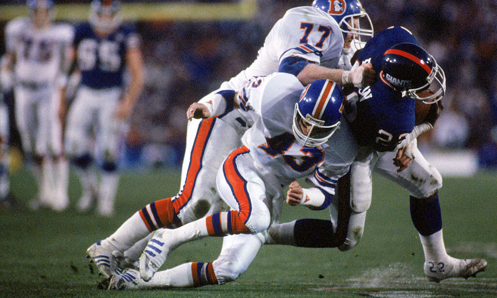 Linebacker Karl Mecklenburg #77 and defensive back Steve Foley #43 of the Denver Broncos...