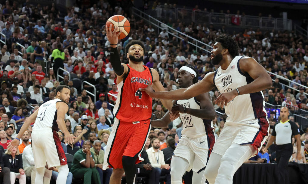 amal Murray #4 of Canada shoots a layup against Jrue Holiday #12 and Joel Embiid #11 of the United ...
