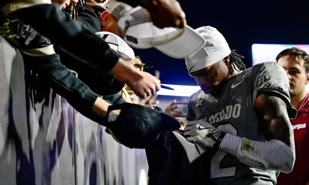 Travis Hunter #12 of the Colorado Buffaloes signs autographs for supporters after a win in a game a...