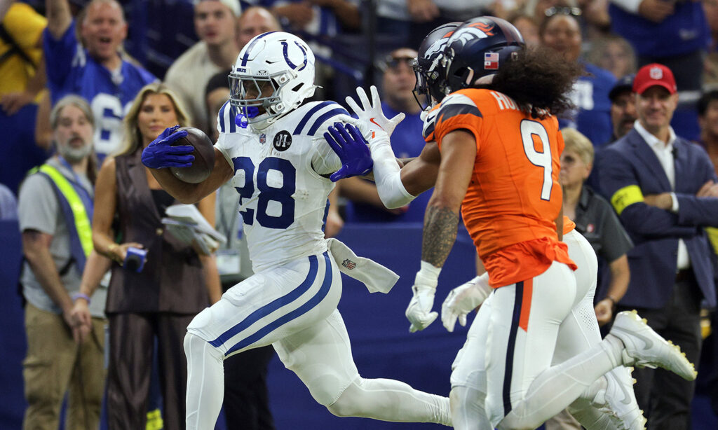 Jonathan Taylor runs past Broncos safety Talanoa Hufanga