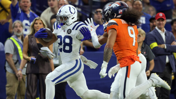 Jonathan Taylor runs past Broncos safety Talanoa Hufanga