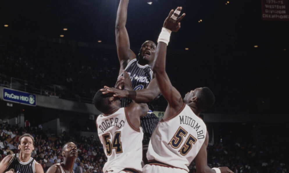 Shaquille O'Neal #32, Center for the Orlando Magic rolls a layup to the hoop as #55 Dikembe Mutombo...