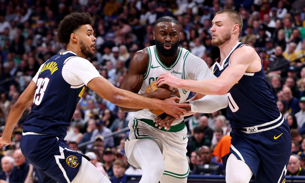 DENVER, COLORADO - FEBRUARY 25: Jaylen Brown #7 of the Boston Celtics drives against Cameron Johnso...