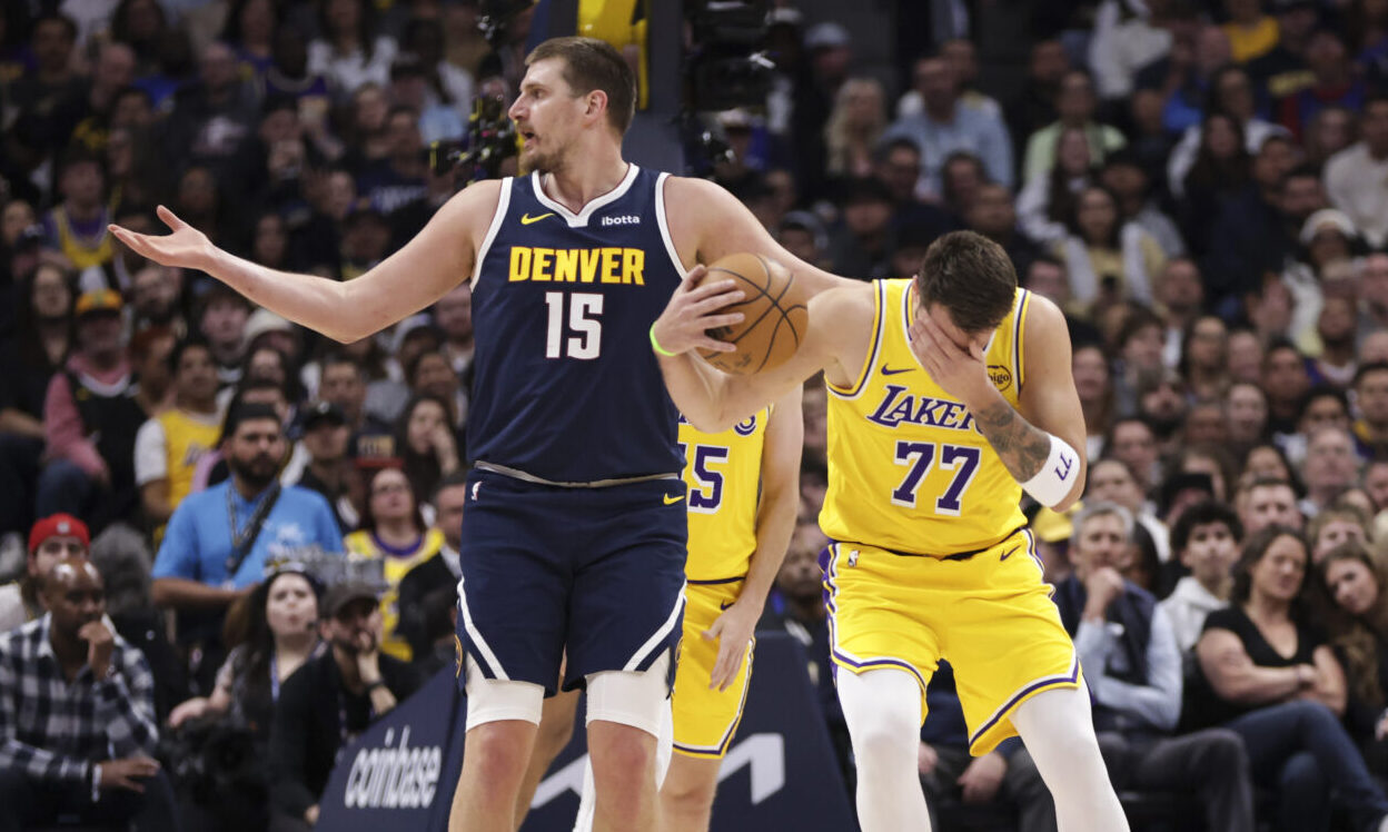 DENVER, COLORADO - MARCH 5: Luka Doncic #77 of the Los Angeles Lakers grabs his face as Nikola Joki...