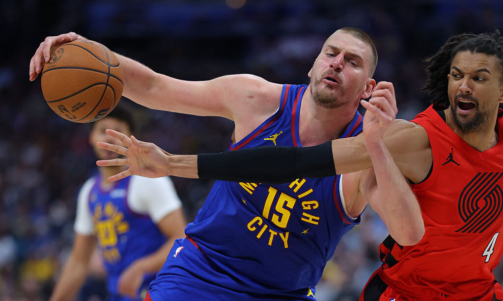 DENVER, CO - MARCH 22: Nikola Jokic #15 of the Denver Nuggets controls the ball while being defende...