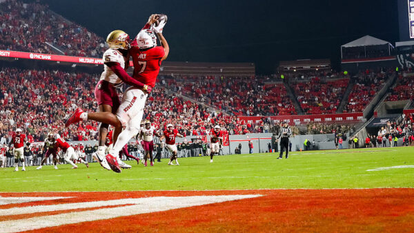RALEIGH, NORTH CAROLINA - NOVEMBER 21: Justin Joly #7 of the NC State Wolfpack catches a touchdown pass over Shamar Arnoux #15 of the Florida State Seminoles during the second half of a football game at Carter-Finley Stadium on November 21, 2025 in Raleigh, North Carolina.