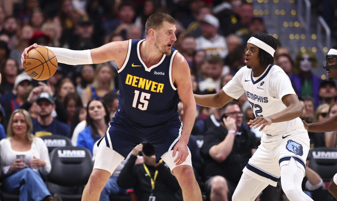 DENVER, COLORADO - APRIL 8: Nikola Jokic #15 of the Denver Nuggets is defended by Adama Bal #72 of ...
