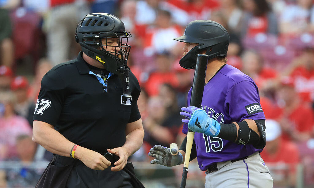 CINCINNATI, OHIO - APRIL 28: Hunter Goodman #15 of the Colorado Rockies exchanges words with home p...