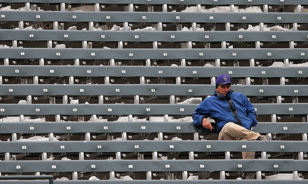 DENVER, CO - APRIL 16: A lone fan sits in the snow covered left field seats to watch the game betwe...