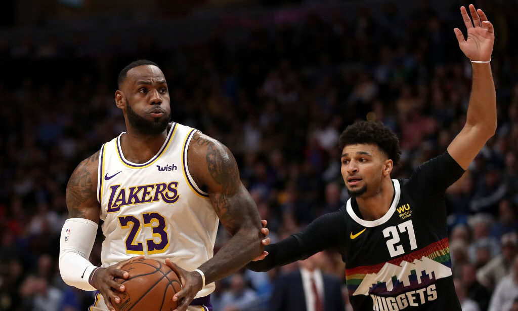 DENVER, COLORADO - DECEMBER 03: Lebron James #23 of the Los Angeles Lakers drives against Jamal Mur...