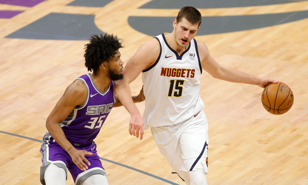 SACRAMENTO, CALIFORNIA - DECEMBER 29: Nikola Jokic #15 of the Denver Nuggets is guarded by Marvin B...