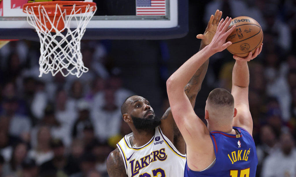 DENVER, COLORADO - APRIL 20: LeBron James #23 of the Los Angeles Lakers guards Nikola Jokic #15 of ...