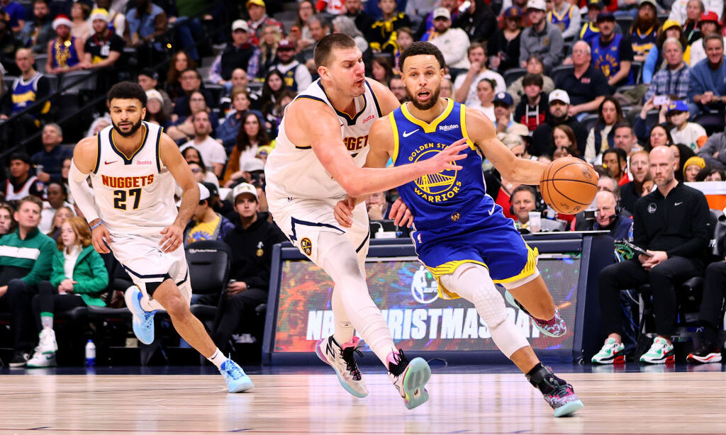 DENVER, COLORADO - DECEMBER 25: Stephen Curry #30 of the Golden State Warriors drives past Nikola J...