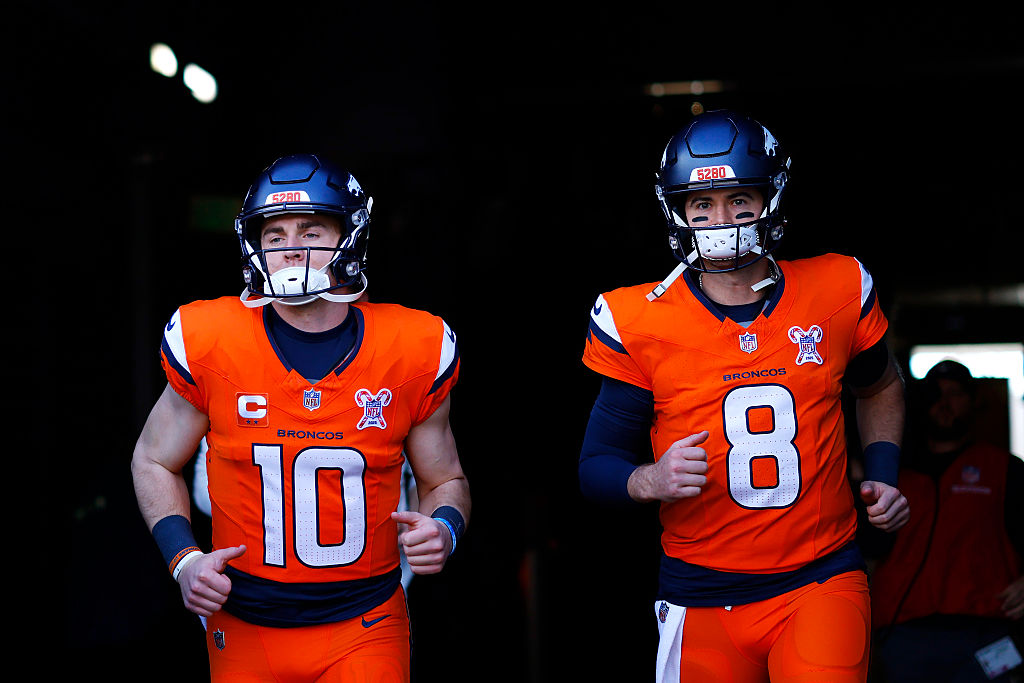 DENVER, COLORADO - DECEMBER 21: Jarrett Stidham #8 and Bo Nix #10 of the Denver Broncos take the fi...