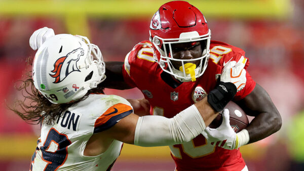 KANSAS CITY, MISSOURI - SEPTEMBER 14: Emmett Johnson #10 of the Kansas City Chiefs runs with the ball against Alex Singleton #49 of the Denver Broncos during the fourth quarter in the game at Arrowhead Stadium on September 14, 2026 in Kansas City, Missouri.