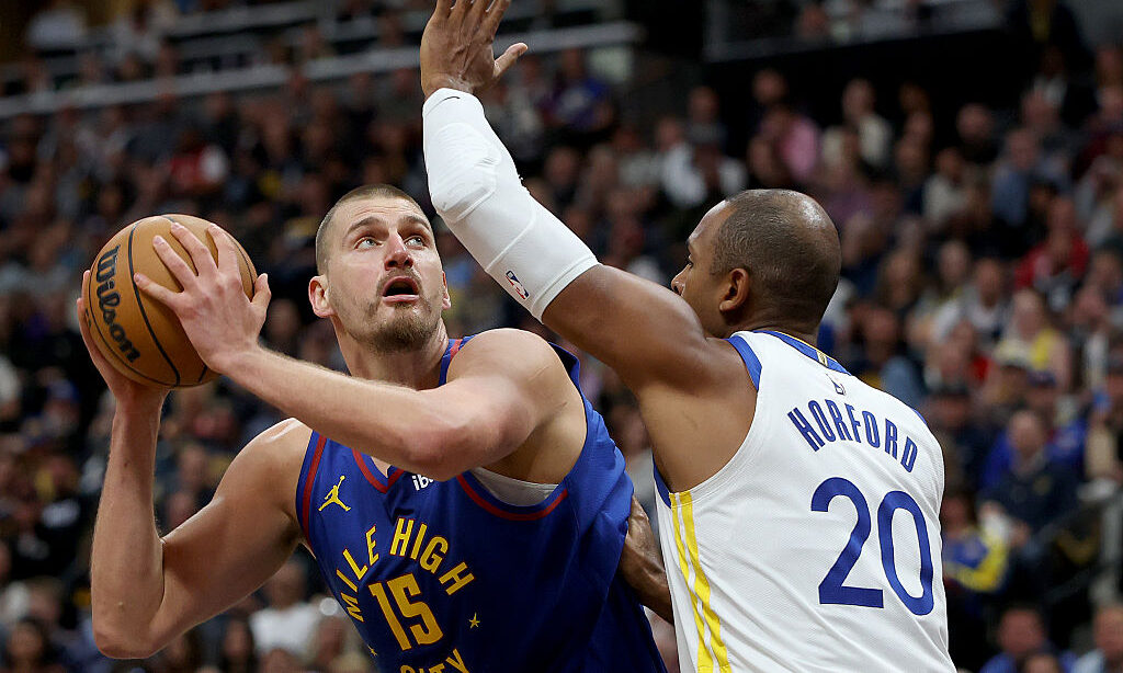 DENVER, COLORADO - OCTOBER 26: Nikola Jokic #15 of the Denver Nuggets goes to the basket against Al Horford #20 of the Golden State Warriors during the first quarter at Ball Arena on October 26, 2026 in Denver, Colorado. NOTE TO USER: User expressly acknowledges and agrees that, by downloading and or using this photograph, User is consenting to the terms and conditions of the Getty Images License Agreement.
